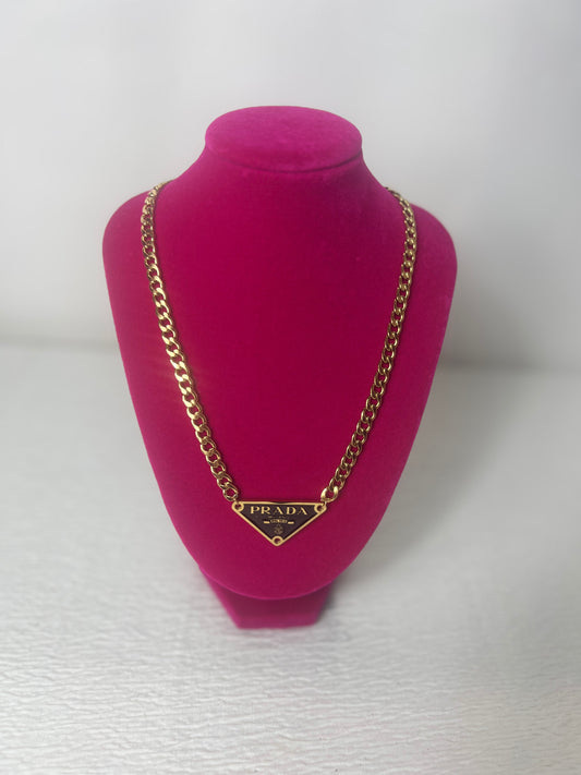 P gold link chain with black pendant.